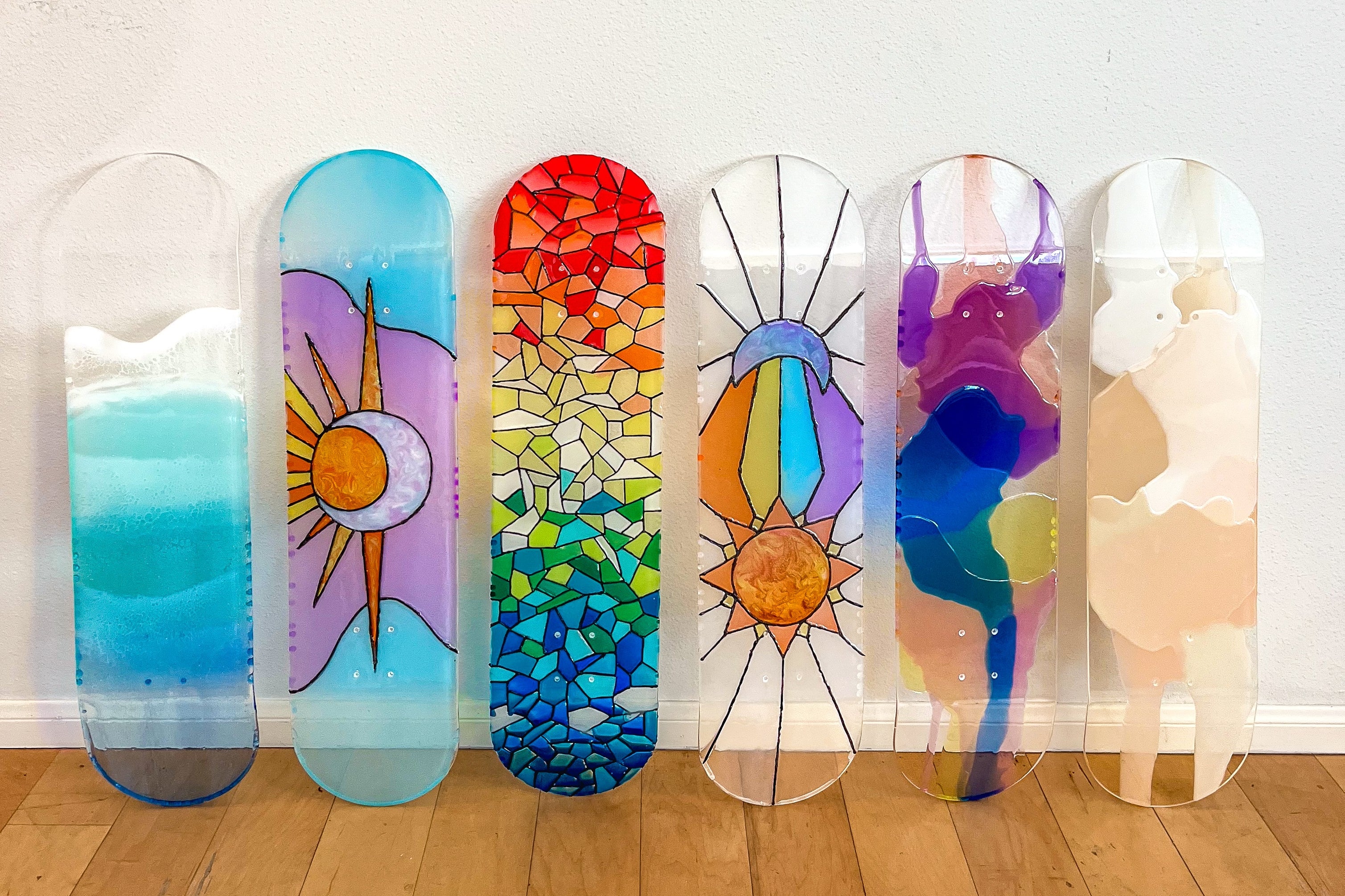 Vibrant see through skateboard art in an array of colors and designs.