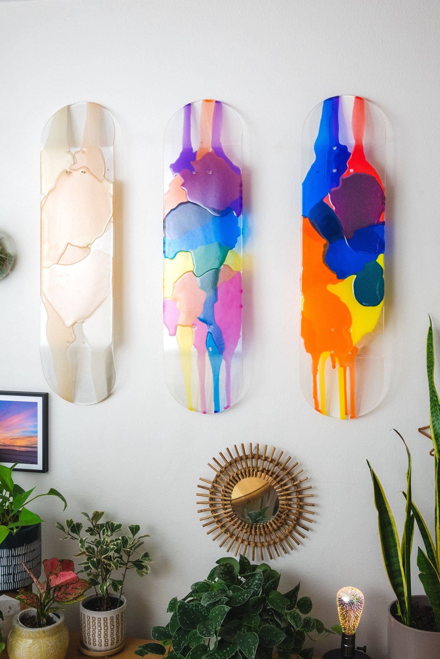 Three piece resin skateboard wall art hanging with colorful shadows.