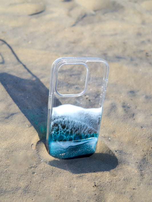 See-through iPhone case with black and blue resin ocean waves.