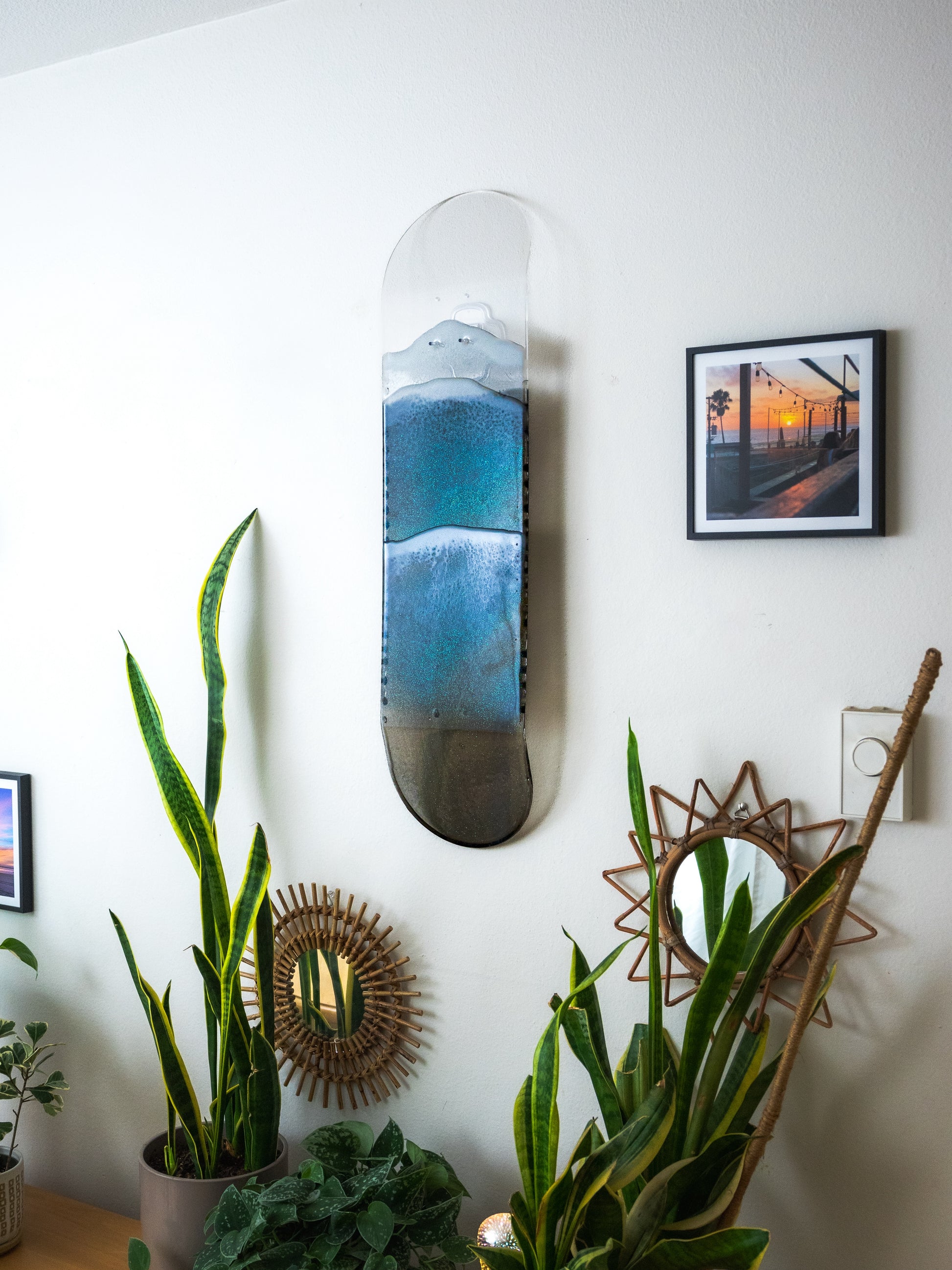 See through black and gold ocean skateboard wall art with iridescent sparkling resin waves.