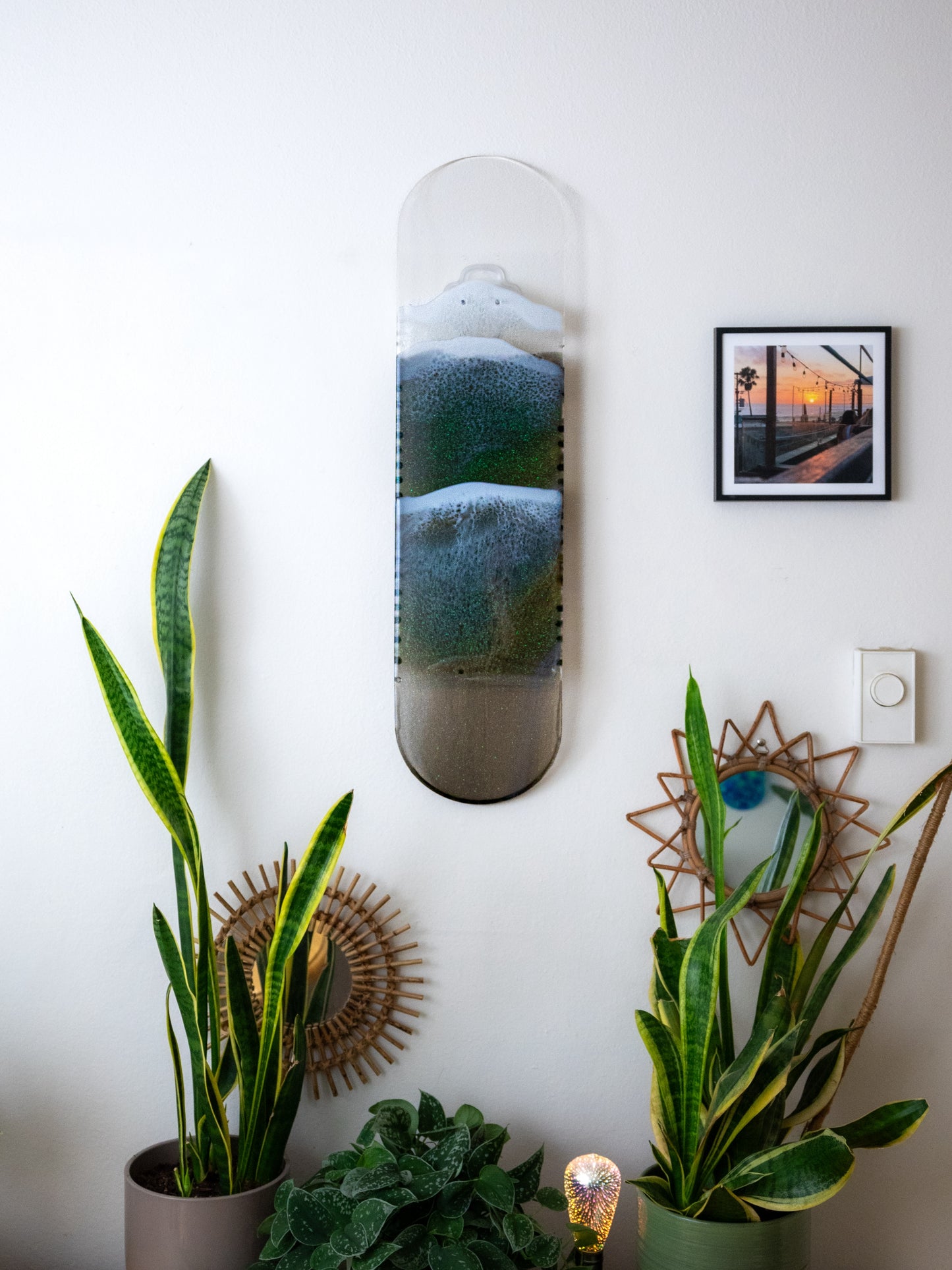 See through black and gold ocean skateboard wall art with iridescent sparkling resin waves.