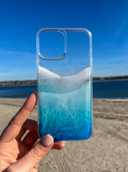 Woman holding a see-through blue resin ocean wave phone case in the Traditional style..