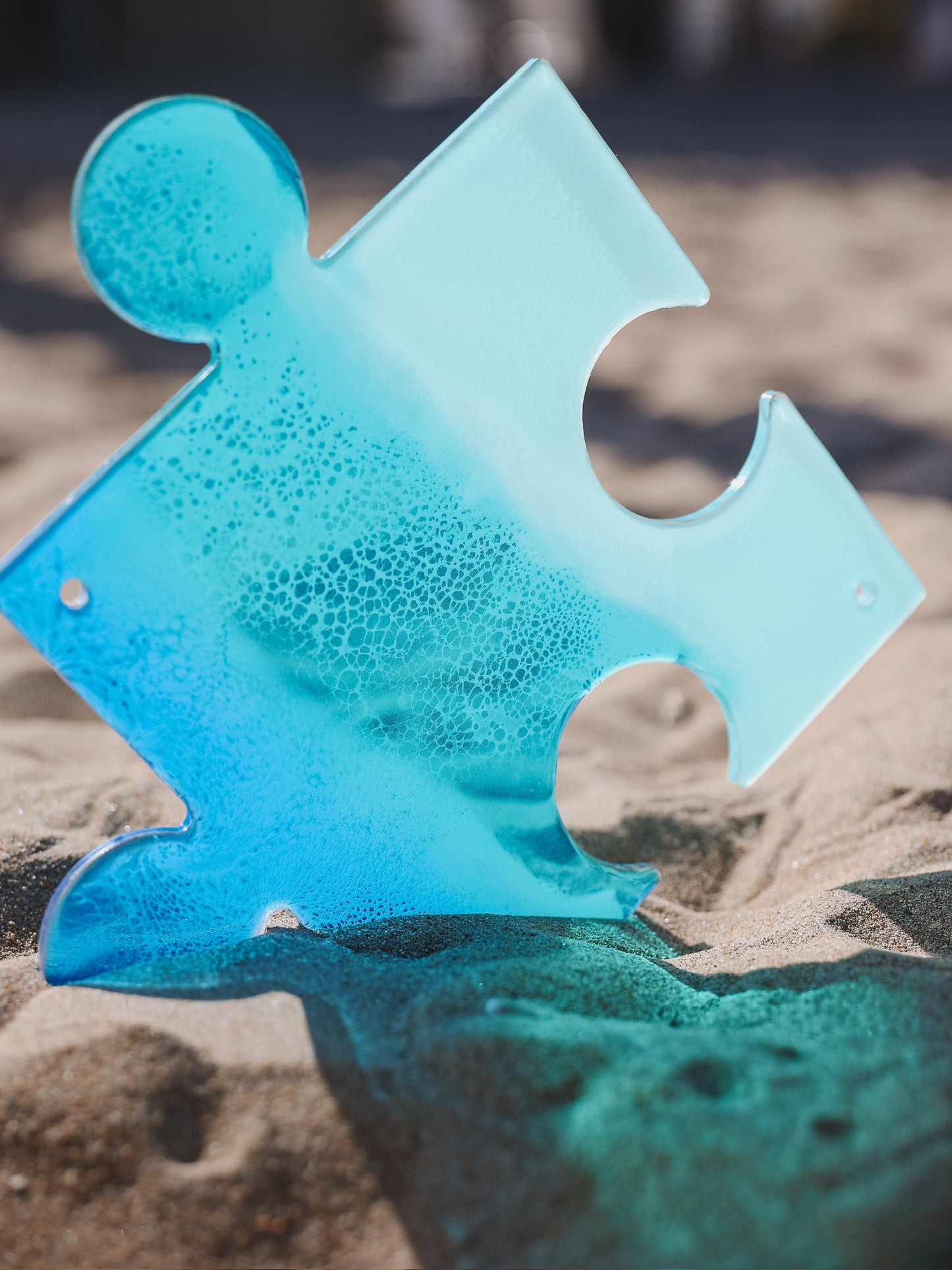 See-through, blue, stained glass ocean wave puzzle piece.
