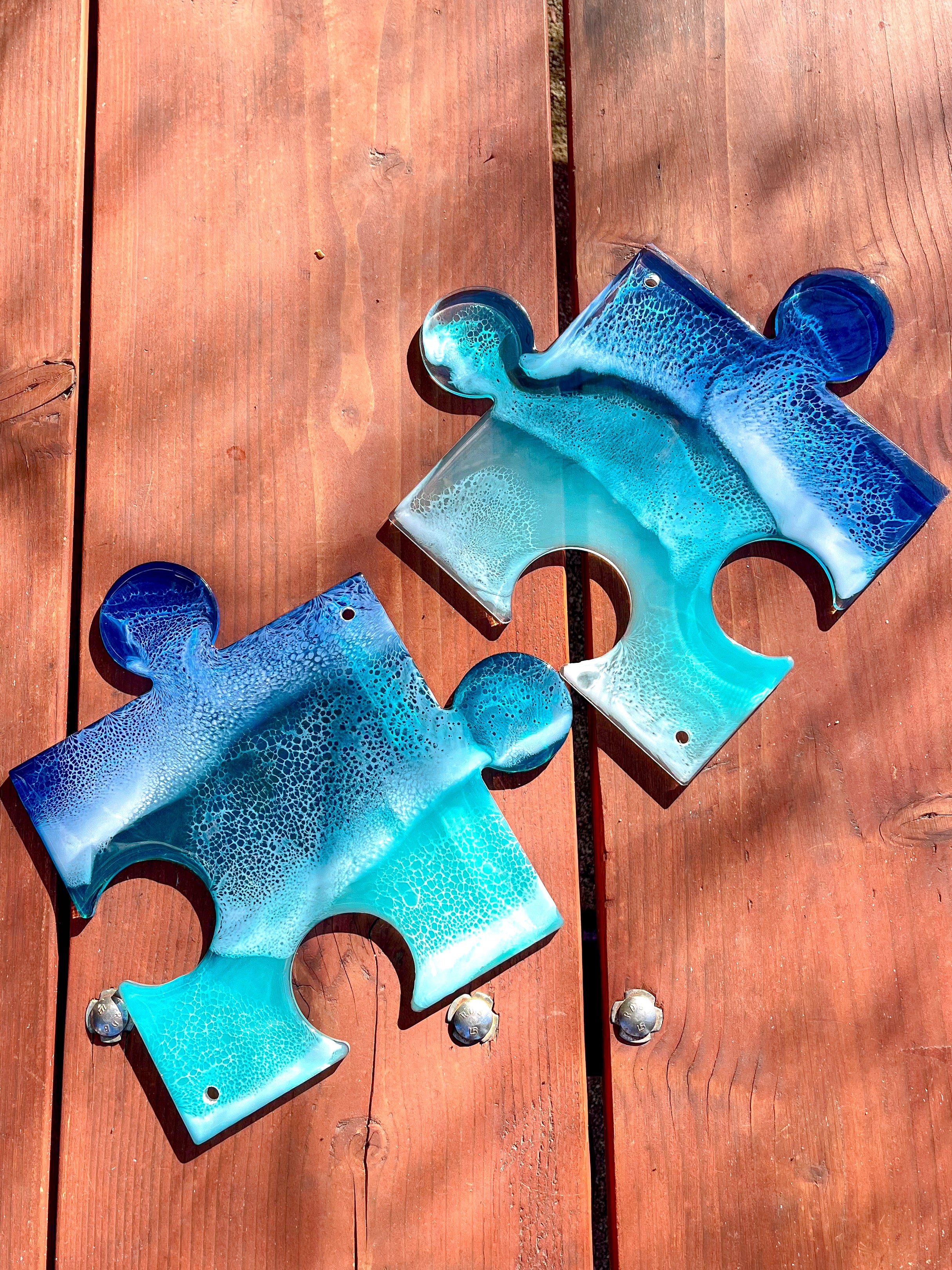 Two see-through blue resin ocean puzzle pieces. Uniquely shaped wall art. 