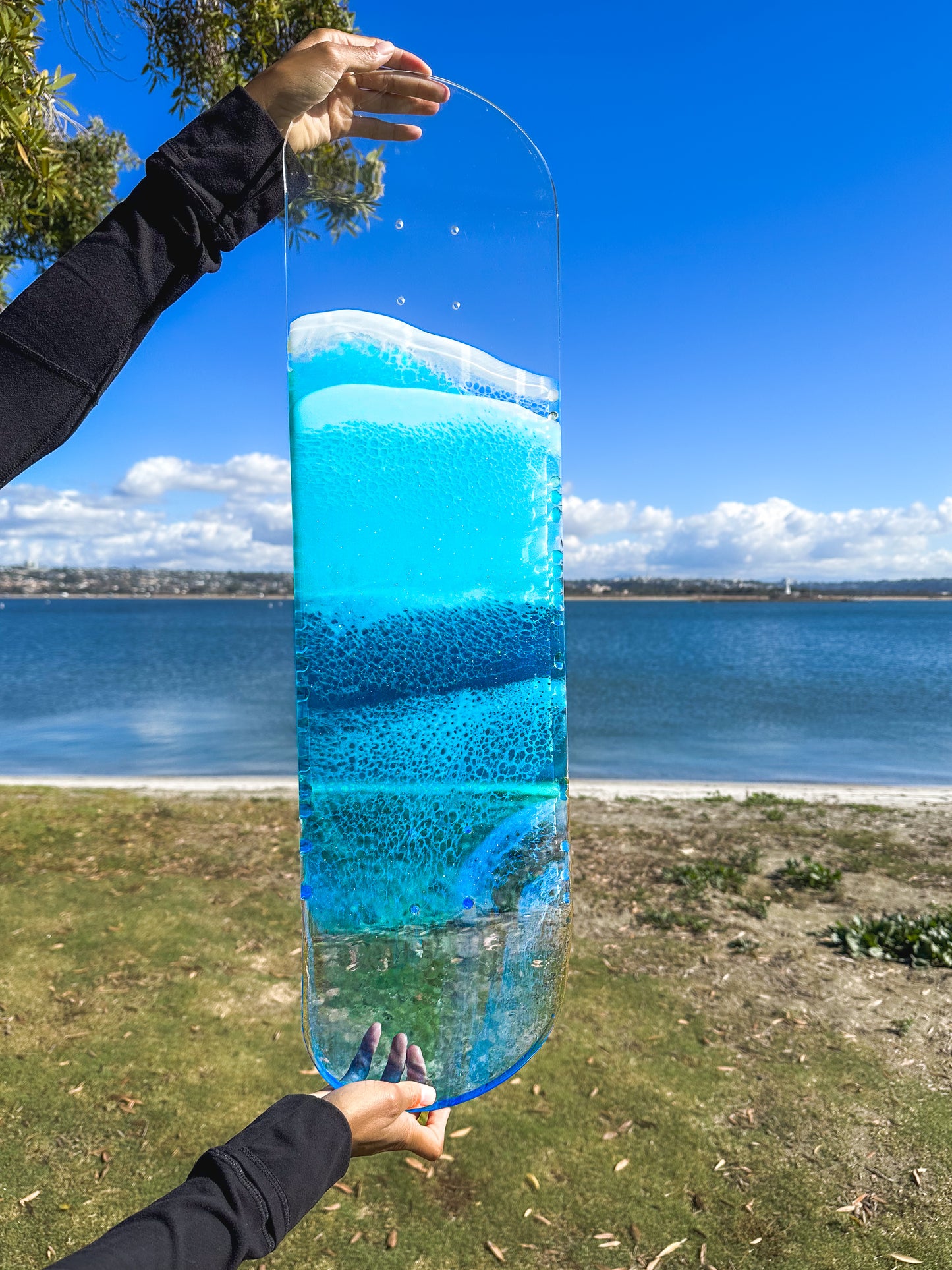 Blue see-through resin ocean skateboard deck art.