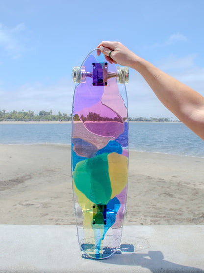 See-through rainbow stained glass skateboard with colorful shadow.