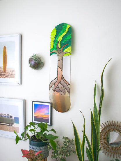 See-through stained glass 'Tree of Life' skateboard wall art with 3D leaves casting colorful shadow on wall.