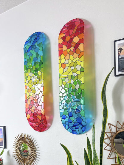 Rainbow stained glass skateboard wall art casting colorful shadows onto wall.
