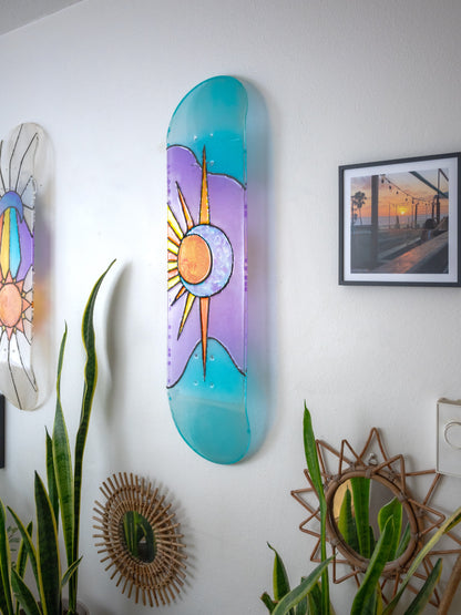 Blue and purple sun and moon stained glass resin skateboard art hanging casting colorful shadow.